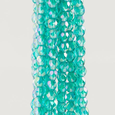 Turquoise glass beads with iridescent finish on a white background